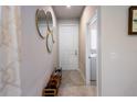 Bright hallway featuring tile flooring, modern mirrors, and easy access to the laundry room at 5029 Grand Teton Ct, Deland, FL 32724
