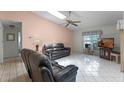 Bright living room featuring tile flooring, ceiling fan, skylights and comfortable leather seating at 5439 E Sacramento Ct, Orlando, FL 32821