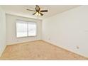 Clean bedroom with neutral carpet, a ceiling fan, and a window for natural light at 5588 Garden Grove Cir, Winter Park, FL 32792