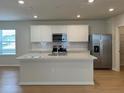 Modern kitchen featuring stainless steel appliances and a large center island at 7408 Olivewood Ave, Orlando, FL 32829