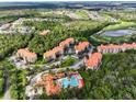Overhead view of the condo community with lush landscaping, a pool, and beautiful buildings with red tile roofs at 8020 Tuscany Way # 6301, Davenport, FL 33896
