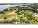 Sprawling property with a long driveway, manicured lawns, and peaceful lake nearby at 9400 Laws Road, Clermont, FL 34714