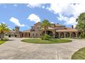 Elegant exterior featuring a circular driveway, arched walkways, and grand entrance at 9400 Laws Road, Clermont, FL 34714