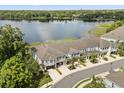 Aerial view of townhomes with lake view, balconies, and lush landscaping at 995 Grand Wildmere, Longwood, FL 32750
