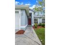 Close-up of the front entrance, showcasing the red door and landscaped walkway at 10675 Fairhaven Way, Orlando, FL 32825