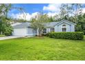 Landscaped front yard with healthy lawn and shade tree at 10675 Fairhaven Way, Orlando, FL 32825