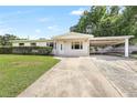 Inviting home exterior with a well-manicured lawn and convenient covered parking at 1204 Marie Ave, Apopka, FL 32703