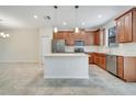 Bright kitchen featuring stainless steel appliances, wooden cabinets, and a white island at 1246 Payne Stewart Dr, Davenport, FL 33896
