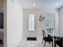 Bright dining area featuring tile flooring, a glass table set, and natural light from a window at 129 Boydfield Ln, Davenport, FL 33837