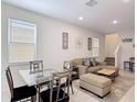 Inviting living room area with comfortable seating, neutral decor, and a dining area, perfect for relaxation at 129 Boydfield Ln, Davenport, FL 33837