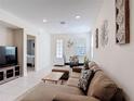 Spacious living room featuring stylish decor, tile flooring, and seamless flow to the dining area at 129 Boydfield Ln, Davenport, FL 33837