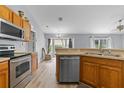 Modern kitchen with stainless steel appliances, oak cabinets, and eat-in breakfast bar at 135 Inconnu Ct, Kissimmee, FL 34759