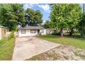 Classic home exterior with a spacious driveway and mature trees providing ample shade at 1422 Russell Ave, Orlando, FL 32806