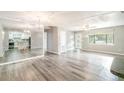 Bright, open-concept living area with hardwood floors and a view into the kitchen and front door at 1422 Russell Ave, Orlando, FL 32806