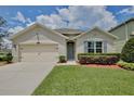 Charming single-story home features a well-kept lawn, tasteful landscaping, and an attached two-car garage at 1565 Diamond Loop Dr, Kissimmee, FL 34744