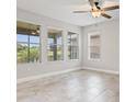 Bright bedroom with tile flooring, ceiling fan, and multiple windows with natural light at 1709 Benoit Ter, Davenport, FL 33837