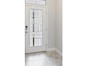 Modern front door with glass panels, tiled floor, and digital lock at 1709 Benoit Ter, Davenport, FL 33837