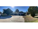 Street view of the house showing the large front yard, two car garage and surrounding trees at 1732 Sw 6Th St, Ocala, FL 34471