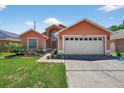 Charming single-Gathering home with a well-manicured lawn, colorful flowers, and an attached two-car garage at 1803 Tillstream Dr, Orlando, FL 32818