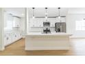 Beautiful kitchen features white cabinets, stainless steel appliances, granite countertops and a kitchen island with pendant lighting at 1824 Dorris Dr, Orlando, FL 32807