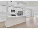 Bright kitchen features modern white cabinets, stainless steel appliances, and a large island for cooking and entertaining at 1824 Dorris Dr, Orlando, FL 32807