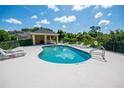Inviting community pool with ample seating, a covered area, and lush greenery surrounding the area at 2673 Rutledge Ct, Winter Haven, FL 33884