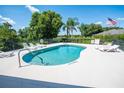 Community pool featuring lounge chairs, lush landscaping and lake views, perfect for relaxation at 2673 Rutledge Ct, Winter Haven, FL 33884