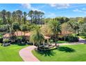 Beautiful home featuring a terracotta roof, arched windows, mature trees, lush landscaping and brick driveway at 3130 Butler Bay N Dr, Windermere, FL 34786