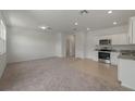Inviting open-concept living space with plush carpeting, tile floors and recessed lighting at 3398 Vesara Dr, Davenport, FL 33837