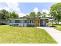 Inviting single-story home featuring well maintained lawn, covered carport and a welcoming yellow front door at 3515 Leslie Dr, Orlando, FL 32806