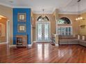 Bright foyer featuring hardwood floors, a decorative glass front door, and ample natural light from large windows at 3619 King George Dr, Orlando, FL 32835