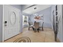 Open dining area with tile floors, modern lighting and a round glass-top table at 401 Gannet Ct, Kissimmee, FL 34759
