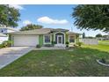 Well-maintained single Gathering home with a lush green lawn and a two-car garage at 401 Gannet Ct, Kissimmee, FL 34759