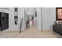Hallway showing tile floors, gray walls, and modern decor leading to the living spaces at 401 Gannet Ct, Kissimmee, FL 34759