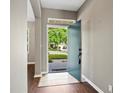 Inviting entryway boasts neutral walls, tile transition, wood floors, and a view of the front yard at 413 Pursley Dr, Deland, FL 32724