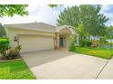 Single-story home boasts an attached garage, blue door, and well-maintained landscaping at 413 Pursley Dr, Deland, FL 32724