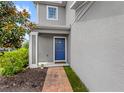 Charming blue front door with brick walkway and beautiful landscaping at 4301 Creek Bank Dr, Kissimmee, FL 34744