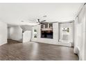 Bright living room featuring hardwood floors, built-in shelving, and large windows at 4301 Creek Bank Dr, Kissimmee, FL 34744