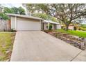 Inviting home exterior featuring a two-car garage, neutral siding, and stone-lined flower beds and driveway at 452 Sundown Trl, Casselberry, FL 32707