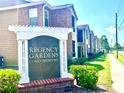 Regency Gardens Condominiums sign with manicured landscaping, brick accents and street views at 5500 Devonbriar Way # 202, Orlando, FL 32822