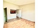 Living area showcasing hardwood floors, adjacent kitchen with dark cabinets, and neutral paint at 5500 Devonbriar Way # 202, Orlando, FL 32822