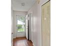 Hallway with an open door showcasing a view of the outdoors and wood-look laminate floors at 628 Olympic Dr # 8-C, Ocoee, FL 34761