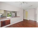 Open living space with wood-look floors, ceiling fan and pass-through to the kitchen at 628 Olympic Dr # 8-C, Ocoee, FL 34761