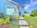 Charming townhome featuring a blue exterior, well-maintained landscaping, and a welcoming walkway at 709 Orchid Dr, Davenport, FL 33897