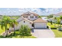Beautiful two-story home with lush landscaping, a tile roof, and waterfront views at 7388 John Hancock Dr, Winter Garden, FL 34787
