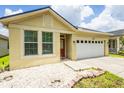 Beautiful home exterior featuring manicured landscaping and a two-car garage at 7557 Azalea Cove Cir, Orlando, FL 32807