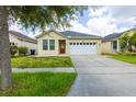 Charming single-story home with a well-manicured lawn and a two-car garage at 7557 Azalea Cove Cir, Orlando, FL 32807