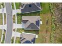 An aerial view shows a well-kept property with solar panels, a driveway, and a lush green lawn at 873 Daring Dr, Davenport, FL 33837