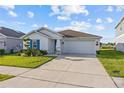 Beautiful single-story home featuring a manicured lawn and a bright blue front door at 873 Daring Dr, Davenport, FL 33837