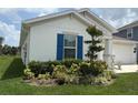Landscaped front yard with blue shutters and well-maintained greenery at 873 Daring Dr, Davenport, FL 33837